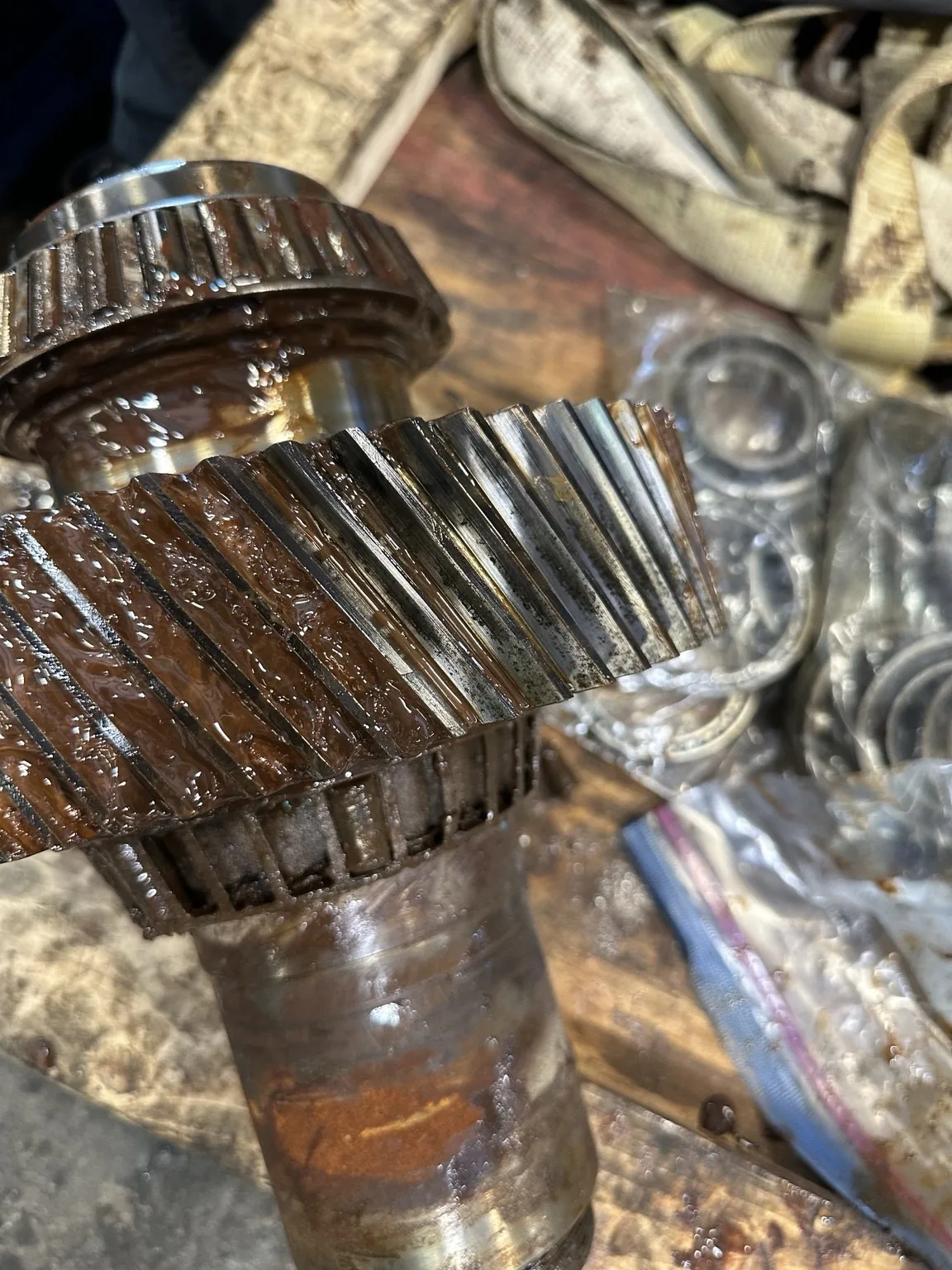 Helical pinion and bearing assembly with visible corrosion and surface deposits.
